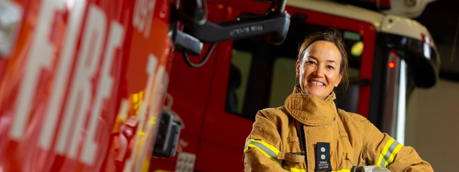 A firefighter in front of a truck 