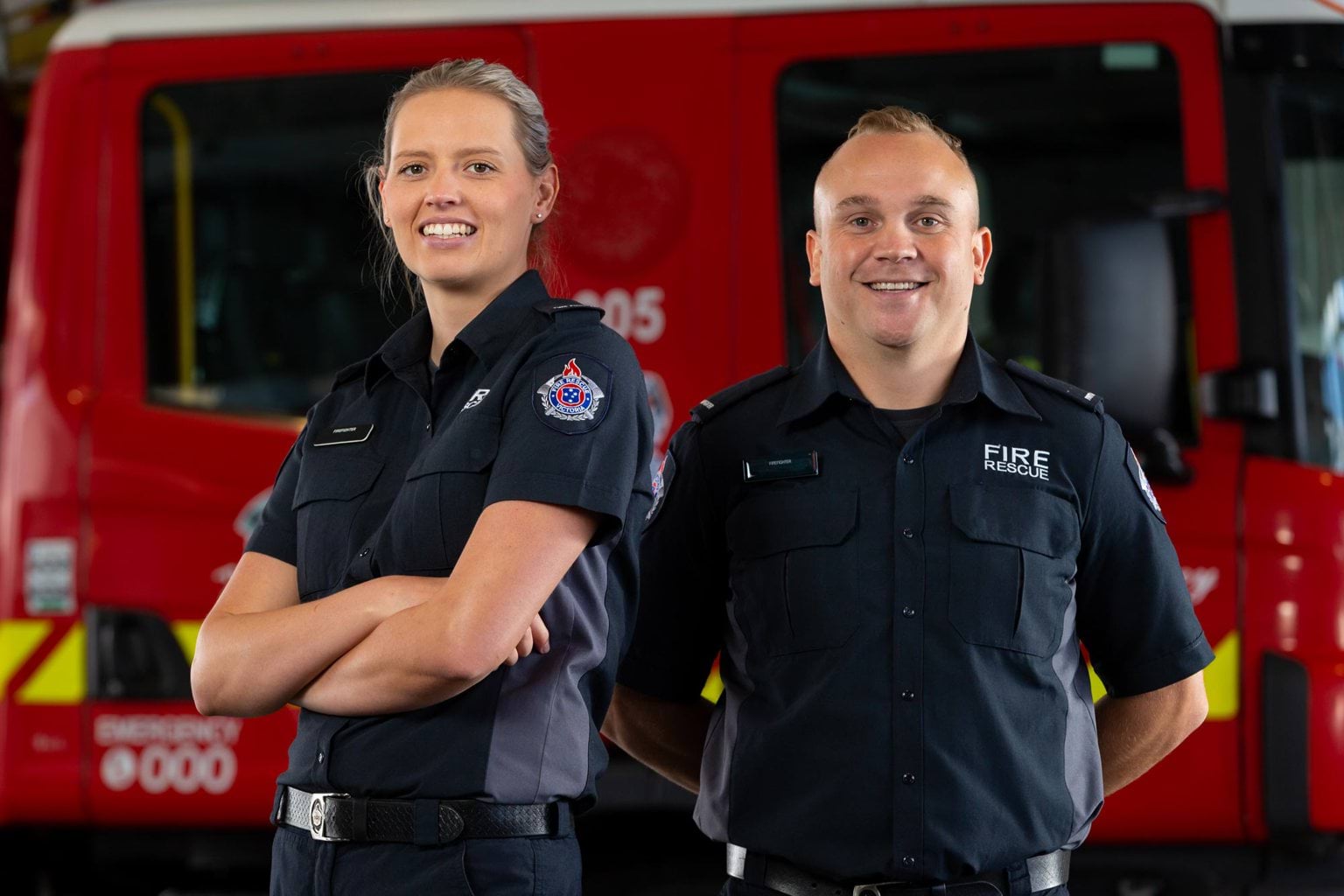 Woman and man firefighter in front of fire truck
