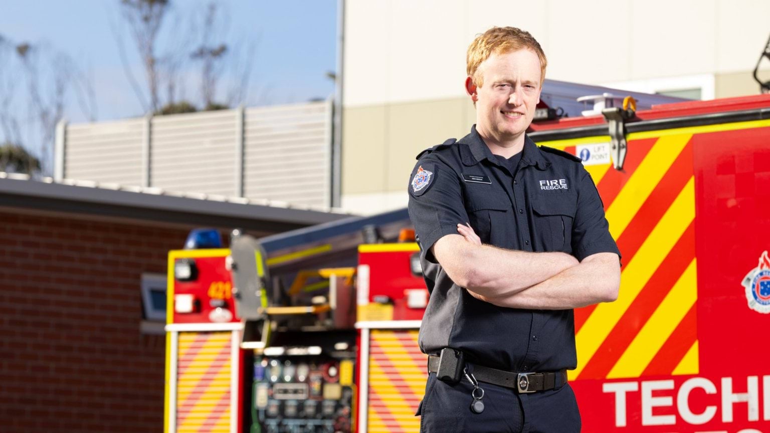 Male firefighter in front of fire truck