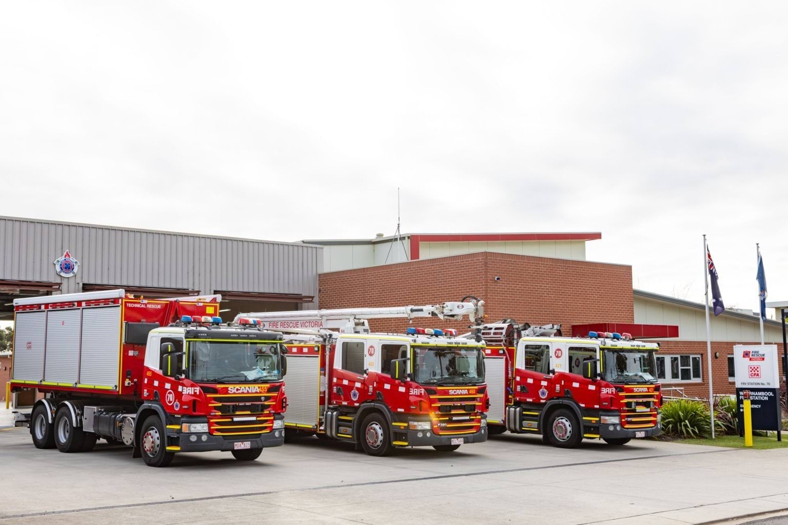Three firetrucks parked in front of fire station