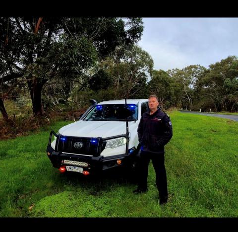 Photo of Commander Chris Manuel, standing next to a ute, smiling at camera.